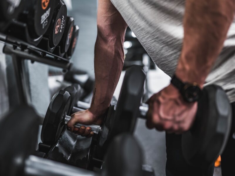 Atleta fazendo exercício com auxílio de personal trainer